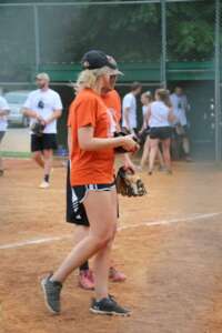female-softball-player-training-with-coach-and-team